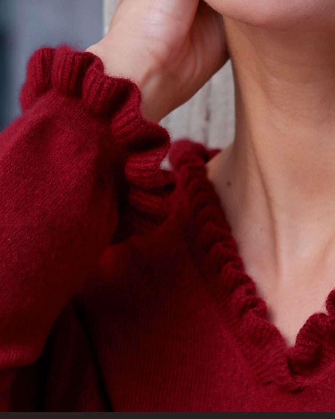 Nærbillede af flæsedetaljer ved halsudskæring, Oyu cashmere bluse i Bordeaux.