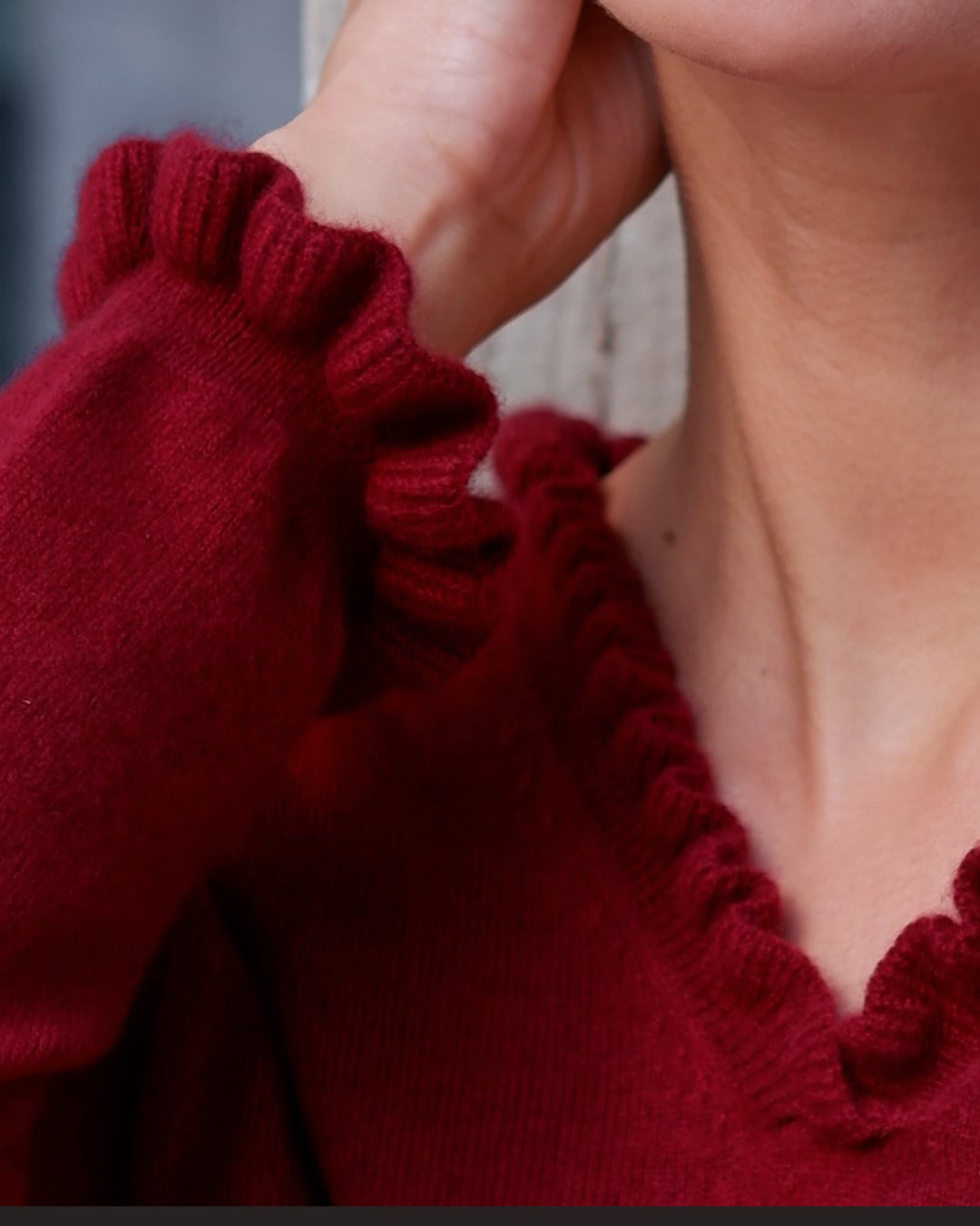 Nærbillede af flæsedetaljer ved halsudskæring, Oyu cashmere bluse i Bordeaux.
