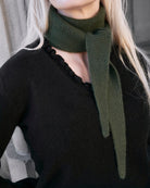Nærbillede af flæsedetaljer ved halsudskæring, Oyu cashmere bluse i Black.