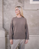 Saran cashmeretrøje i taupe, vist på model i let vinklet positur