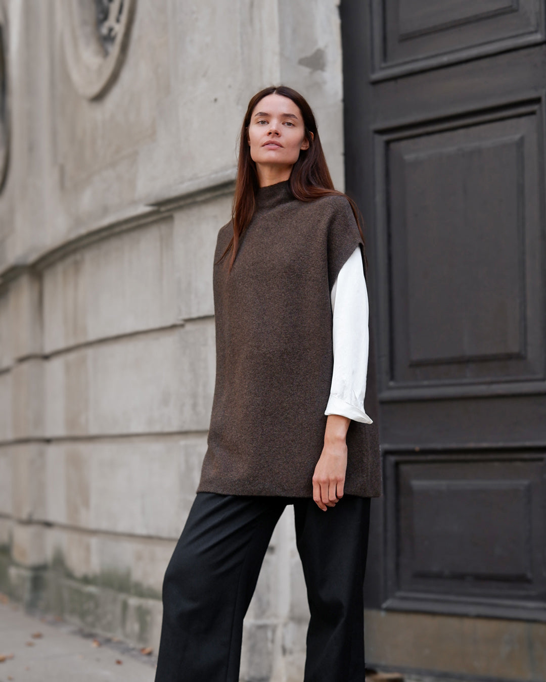 Solongo yakuld vest i natural melange, model foran mørk dør