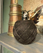 Nøgle yakuld garn i dark brown foran kobberkande.