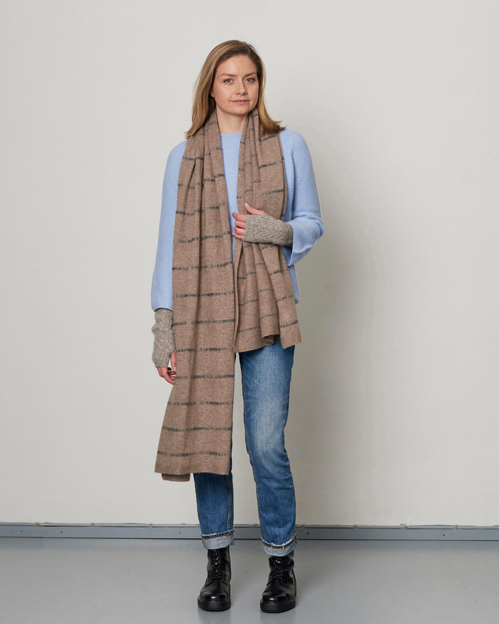 Helbillede af modellen, der viser det stribede cashmere tørklæde elegant draperet.