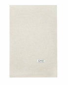 Det store naturfarvede cashmere tørklæde i lys gråbeige ligger fladt.