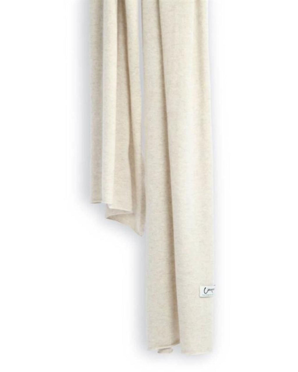 Det store cashmere tørklæde, her i naturfarvet lys gråbeige hænger løst ned.