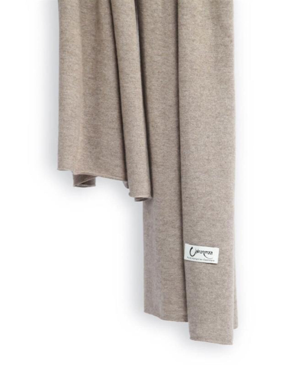 Det store cashmere tørklæde, her i naturfarvet mørk gråbeige hænger løst ned.