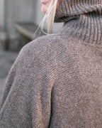 Detalje af skulder på Tara yakuld poncho med rullekrave i Yak Dark Grey.