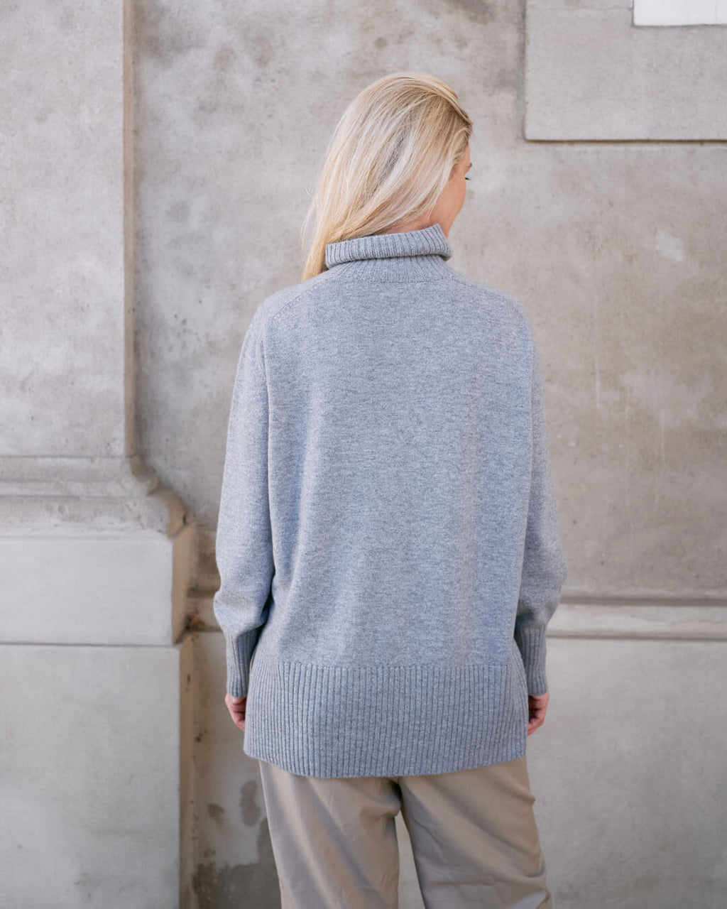 Model iført klassisk cashmere sweater med sadelskuldre og løs pasform i soft grey set bagfra