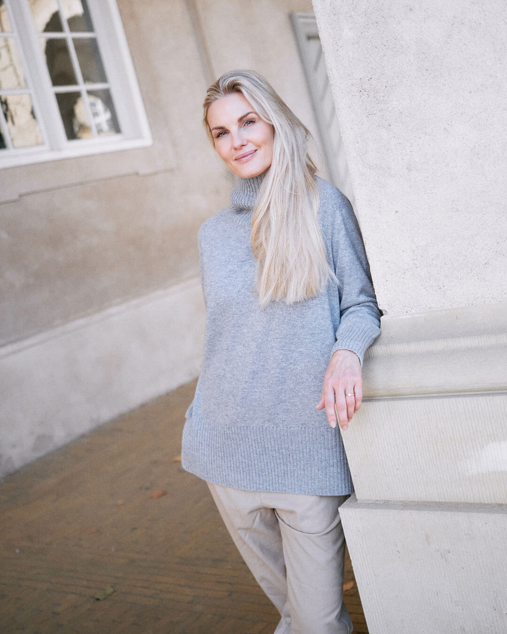 Model iført klassisk cashmere sweater med sadelskuldre og løs pasform i soft grey i afslappet pose