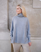 Model iført klassisk cashmere sweater med sadelskuldre og løs pasform i soft grey