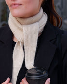 Lyst, ufarvet cashmere tæt ved halsen – detaljer i rillestrik.