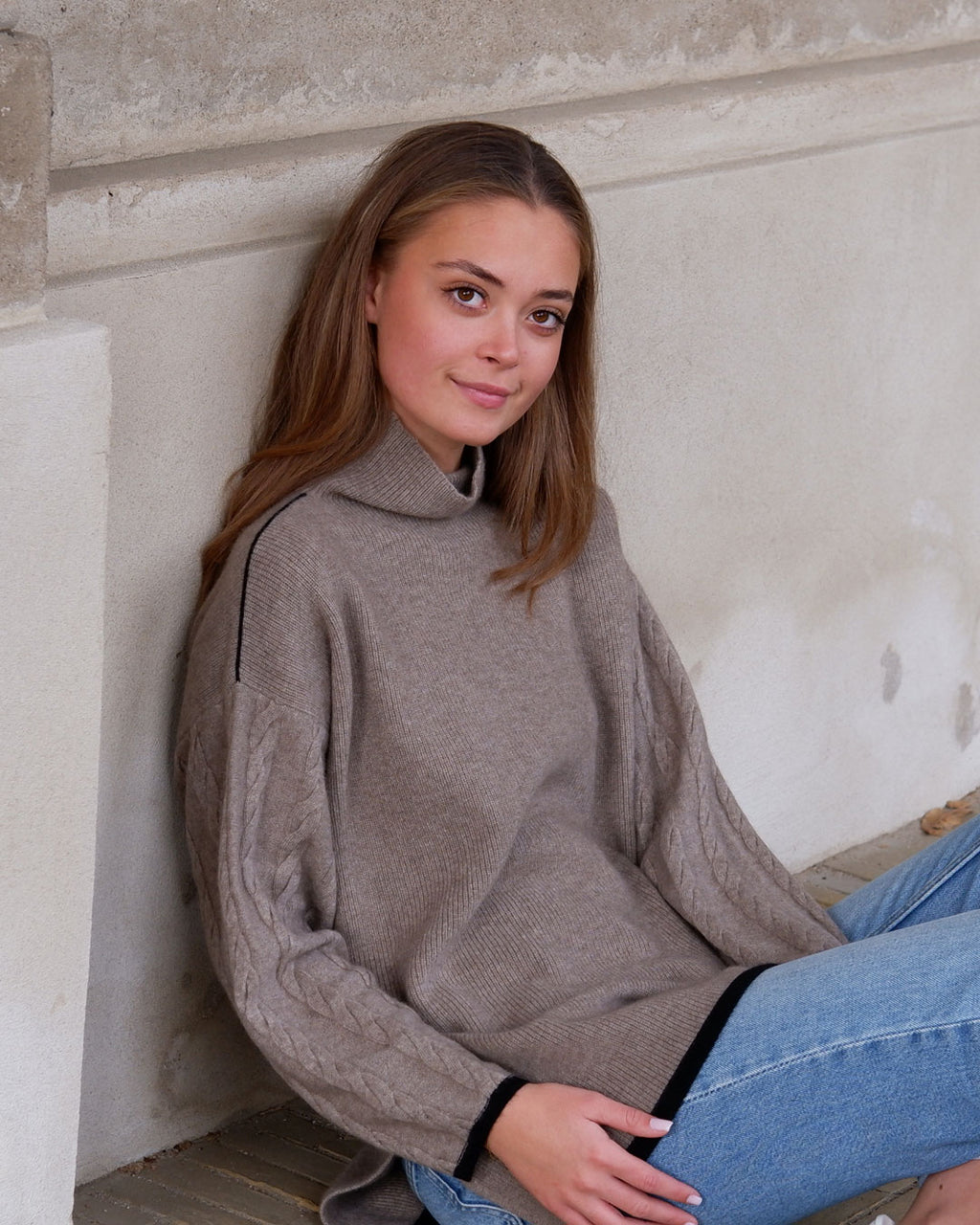 Model iført Tuya cashmere mørk gråbeige rullekravebluse med mønster.