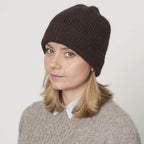 Model med strikket yakuld hue i mørk brun naturfarve. 