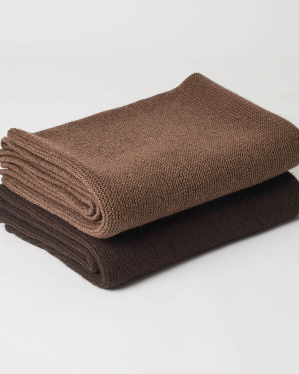 Foldede yakuld plaider, der viser de to farver, mørkebrun og brun, samt deres fyldighed og kvalitet.