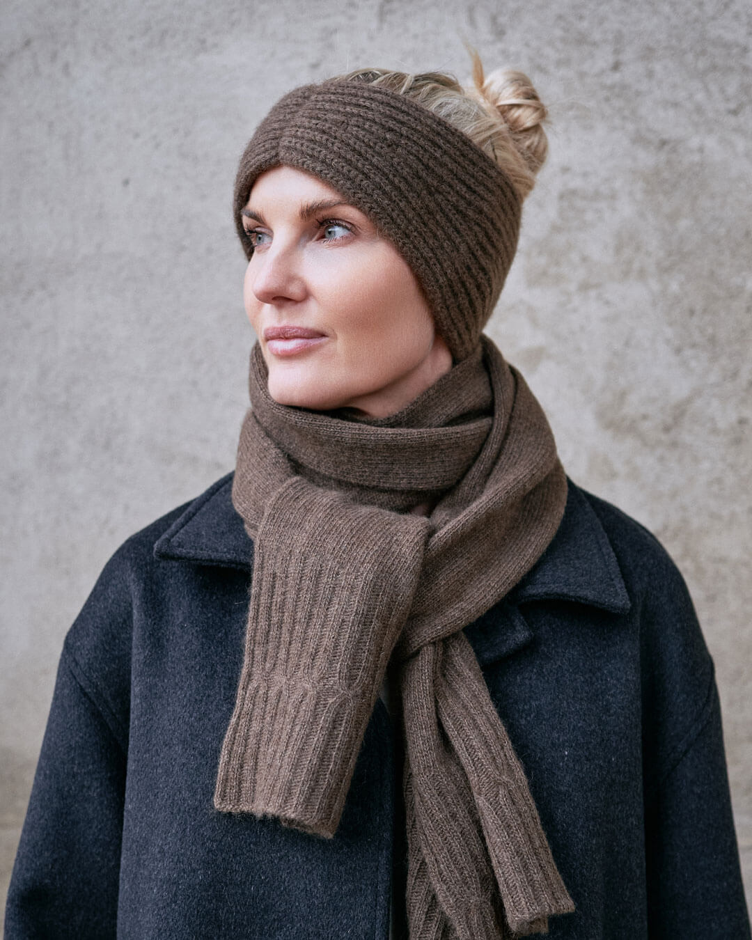 Model i mørk frakke med yak pandebånd i Yak Mocha, klassisk vinterlook.