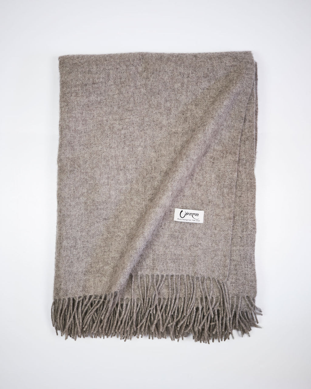 Vævet plaid i 100% yakuld, platinum grey, med frynser og Undarmaa-label.