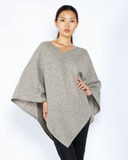 Model iført yakuld poncho i platinum grey med V-udskæring.