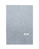Det store tætstrikkede cashmere tørklæde i Light grey ligger fladt.