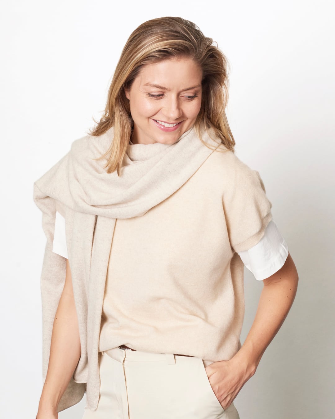 Model med det store naturfarvede cashmere tørklæde i lys gråbeige svøbt om halsen.