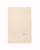Det store naturfarvede cashmere tørklæde i lys beige ligger fladt.