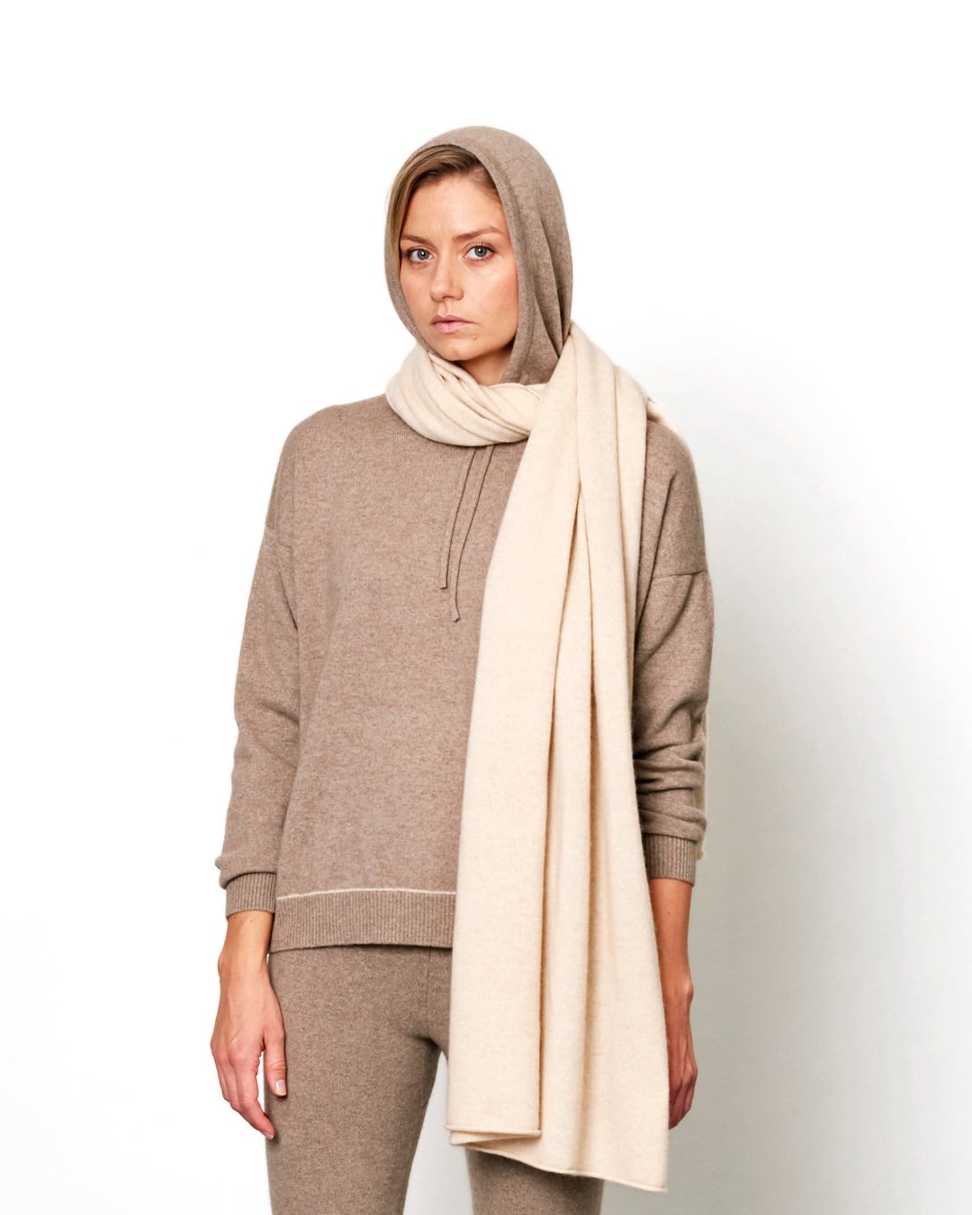 Model med det store naturfarvede cashmere tørklæde i lys beige svøbt om halsen.