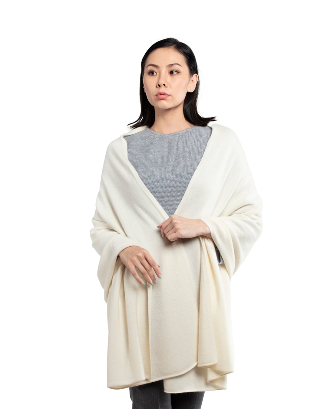 Model med det store naturfarvede cashmere tørklæde i hvid svøbt om halsen.