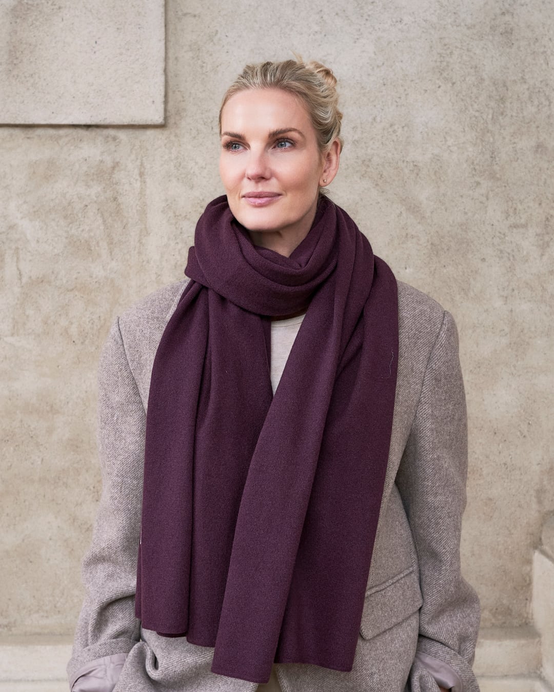 Model med det store tætstrikkede cashmere tørklæde i Violet, draperet løst om halsen.