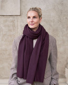 Model med det store tætstrikkede cashmere tørklæde i Violet, draperet løst om halsen.