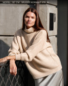 Kvinde iført Zaya turtleneck i Natural sand cashmere, udendørs.