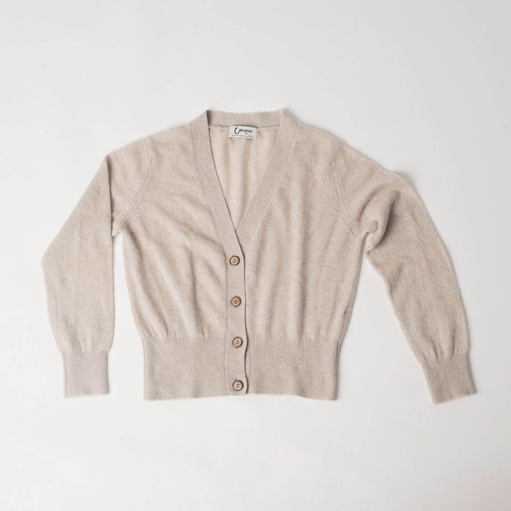 Helhedsbillede af lys camel cashmere cardigan med V-udskæring liggende fladt.