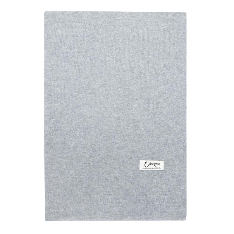 Det store cashmere tørklæde i lys grå ligger fladt og foldet.