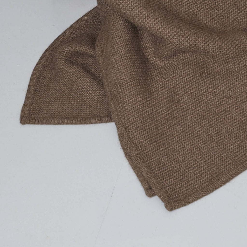 Nærbillede af den mørkebrune naturlige tekstur af yakuld plaiden.