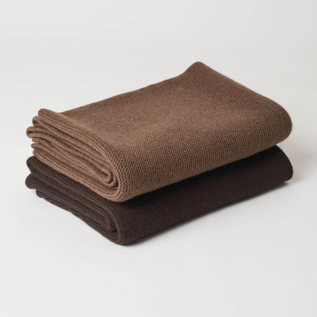 Foldede yakuld plaider, der viser de to farver, mørkebrun og brun, samt deres fyldighed og kvalitet.