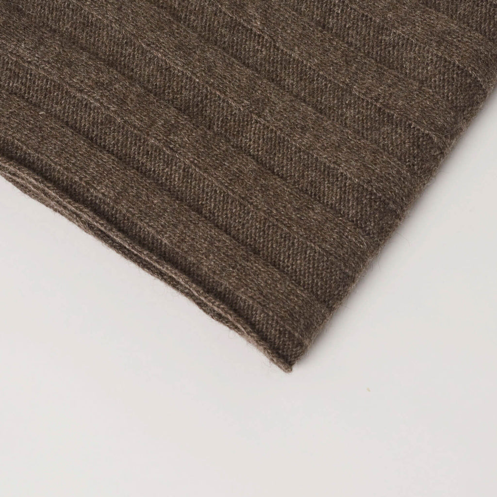 Nærbillede af det ribstrikkede mønster og den gråbrune farve på yakuld tørklædet.